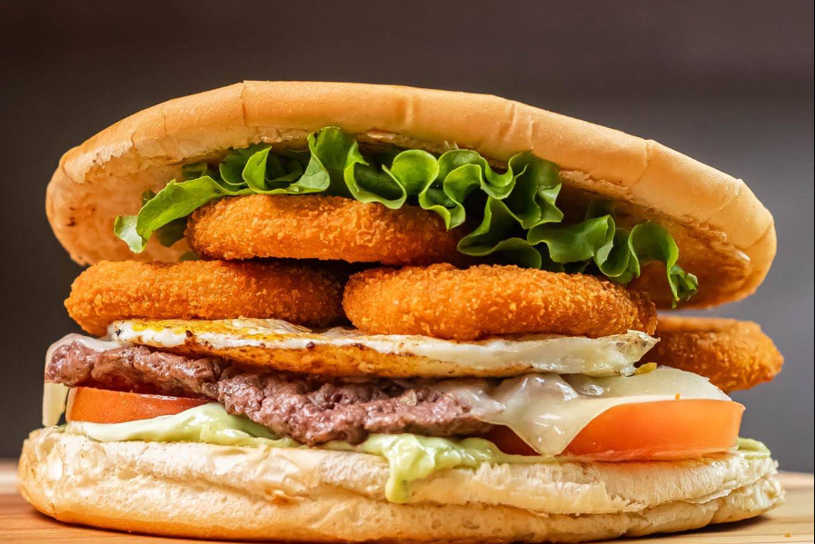 Xis com anéis de cebola, ovo, carne, queijo e salada